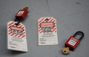 Candados y etiquetas de seguridad Lockout Tagout con mensajes de advertencia en inglés y español.
