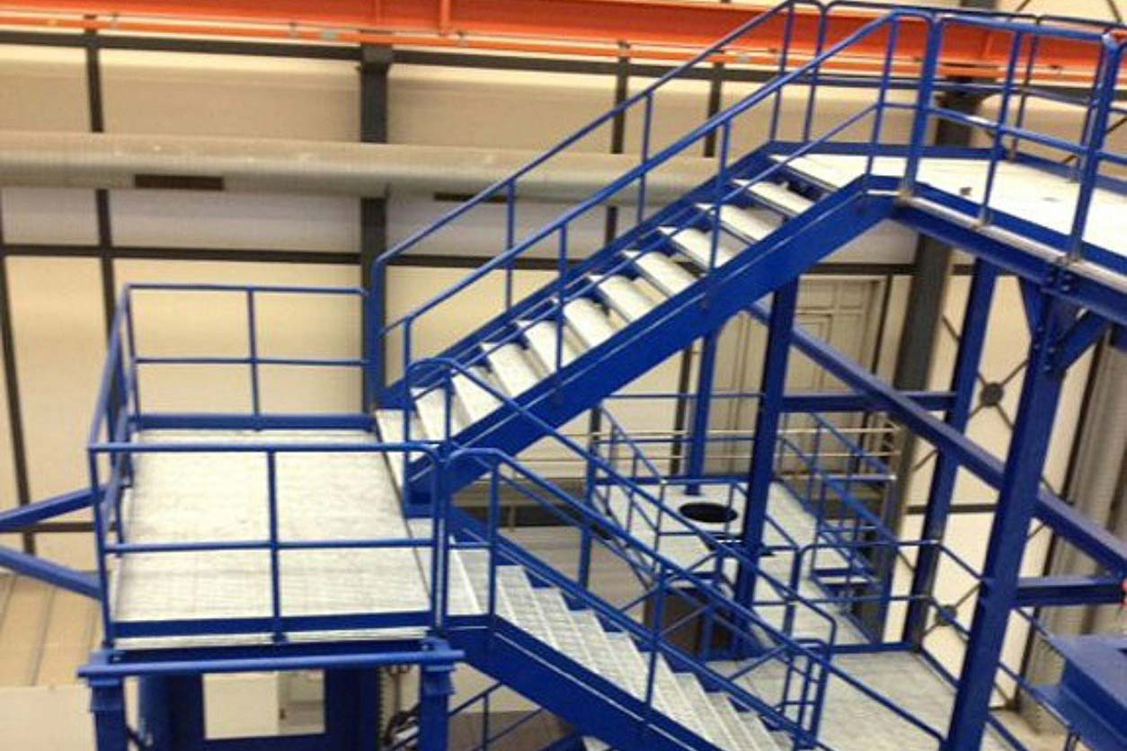 Estructura metálica industrial con escaleras y plataformas de acceso para mantenimiento seguro en plantas industriales.