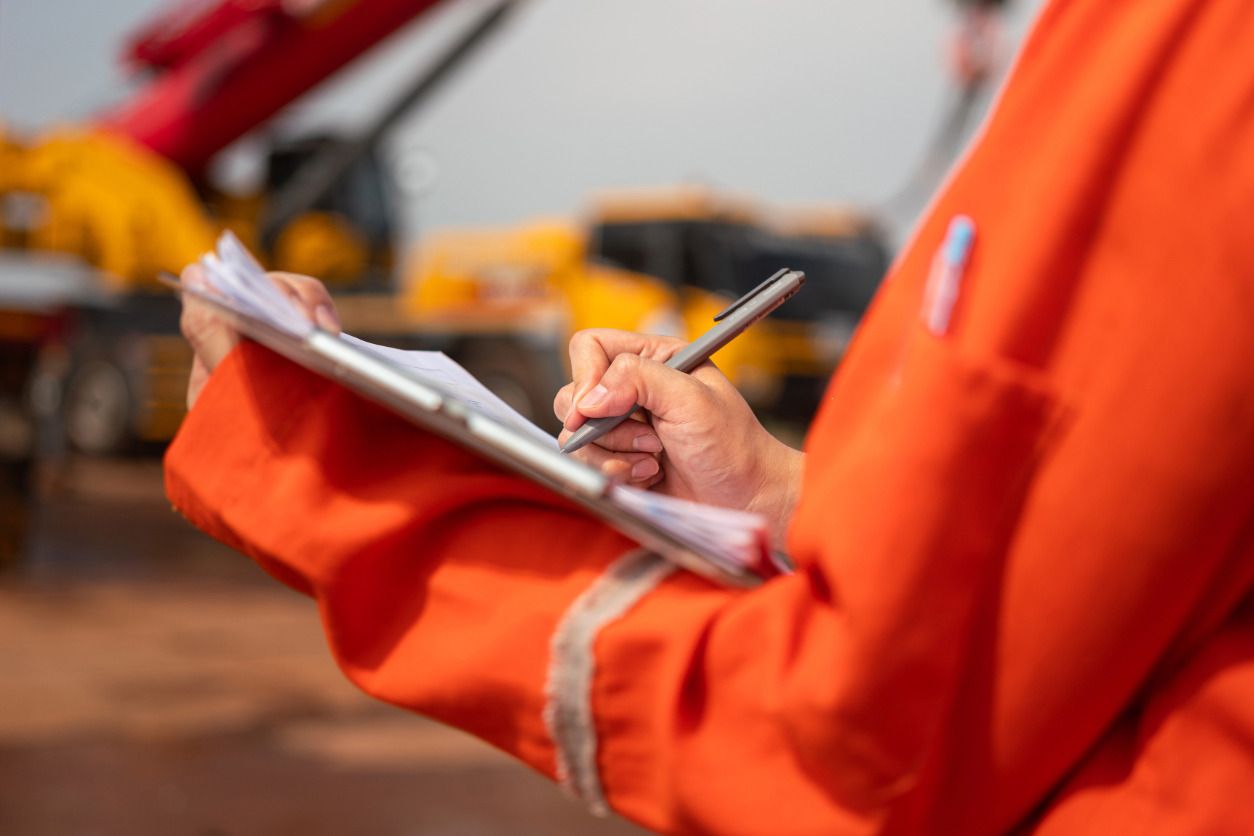 Técnico de prevención de riesgos laborales en obra con checklist de seguridad.
